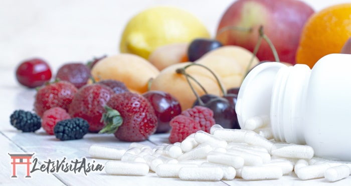 Multivitamins as immune support while traveling among some fruit in the background